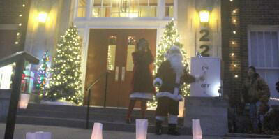 Photo of Santa and Mrs. Claus turn on holiday lights on First Street Community Center building.