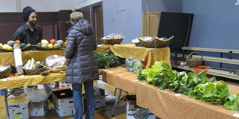 Produce tables and attendees at the Mount Vernon Indoor Winter Farmers' Market