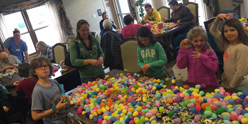 Children Stuffing Colored Eggs with Candy for Easter Egg Das