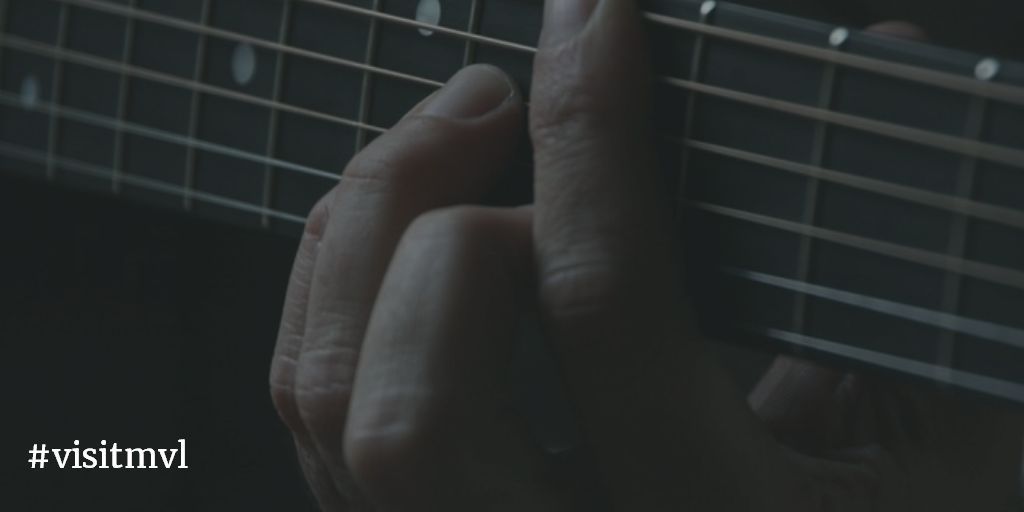 close-up playing guitar chord
