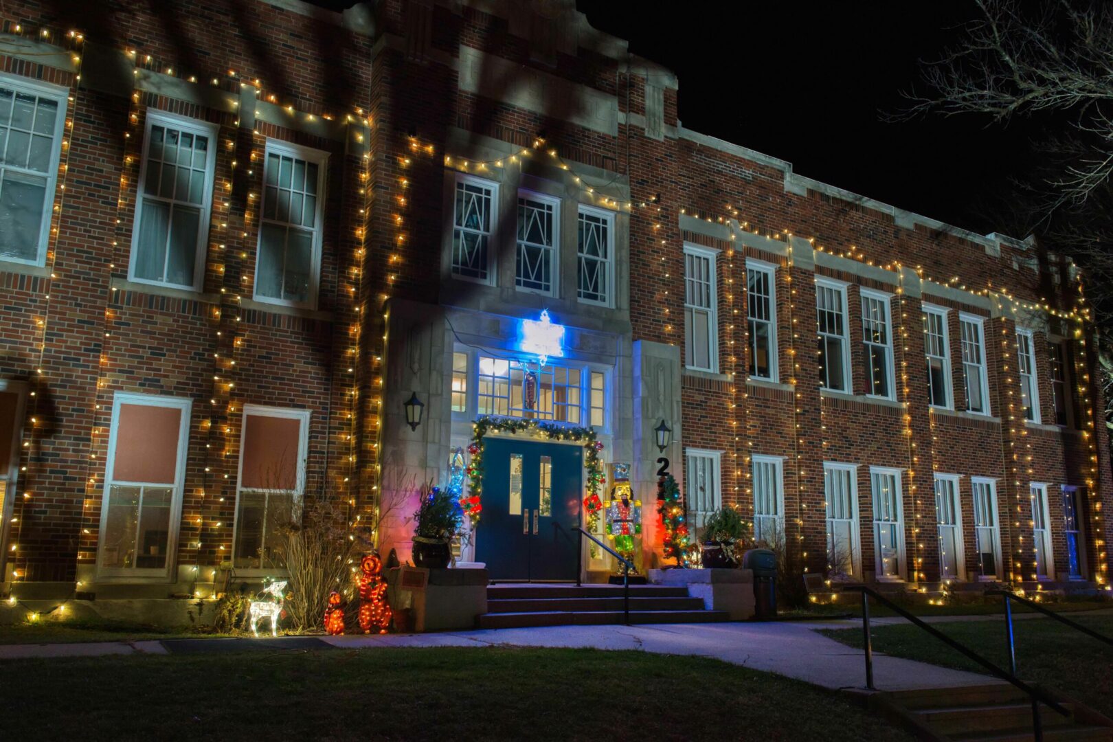 First Street Community Center building at night with seasonal decorative lights on display