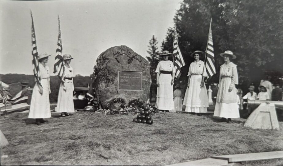 Women with American flags during ceremony at the Gettysburg Boulder