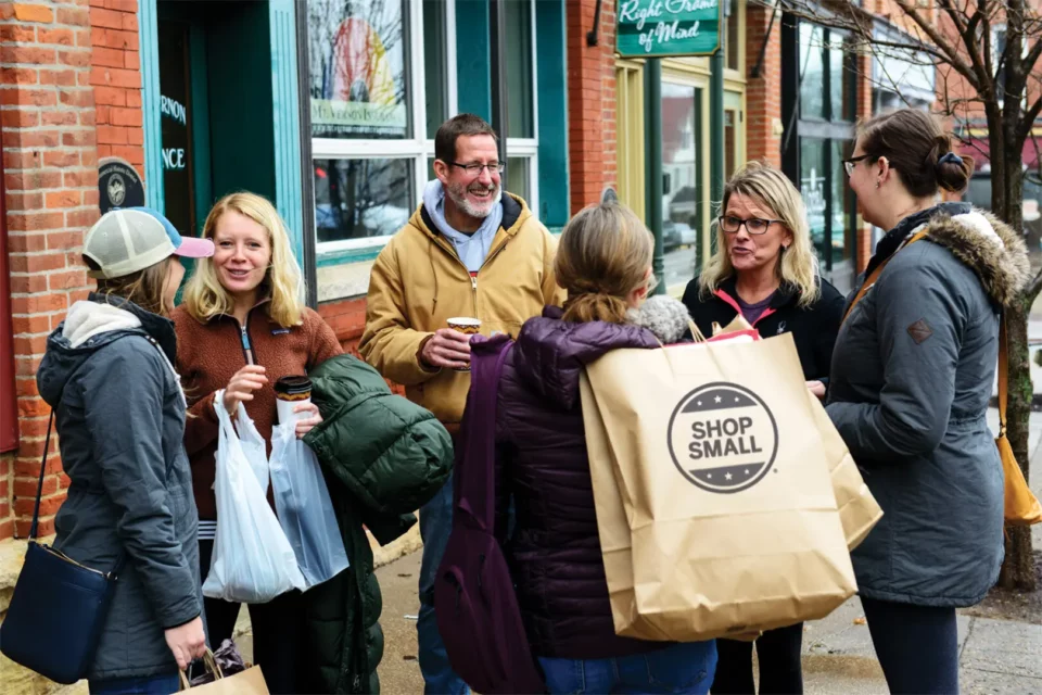people outside on main street with "shop small" shopping bags
