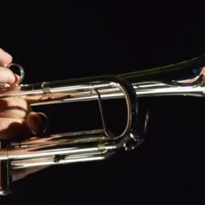 person playing a trumpet with a black background