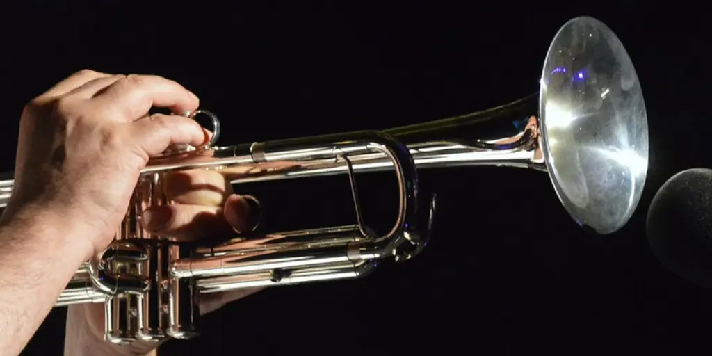 person playing a trumpet with a black background