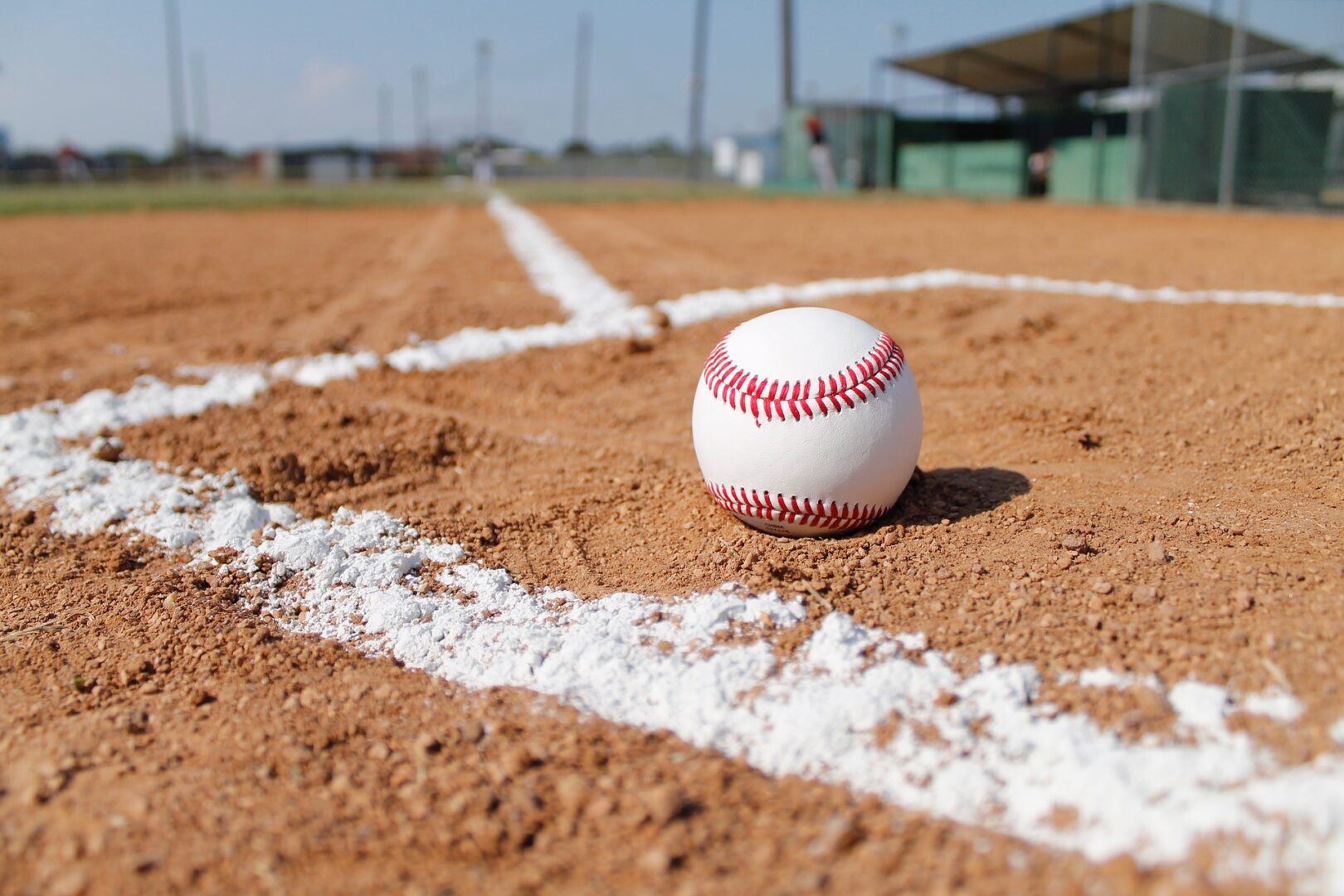baseball sitting on the ground in a baseball field