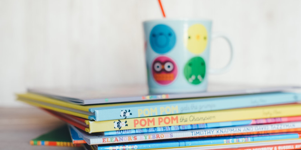 Stack of story books with under a cup
