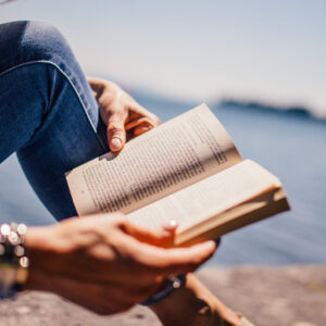 Reading book outside by the water