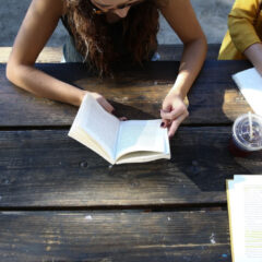 Group reading books at picnic table