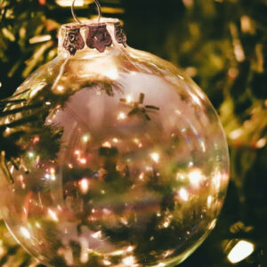 White and gold Christmas Ornament in tree with white lights